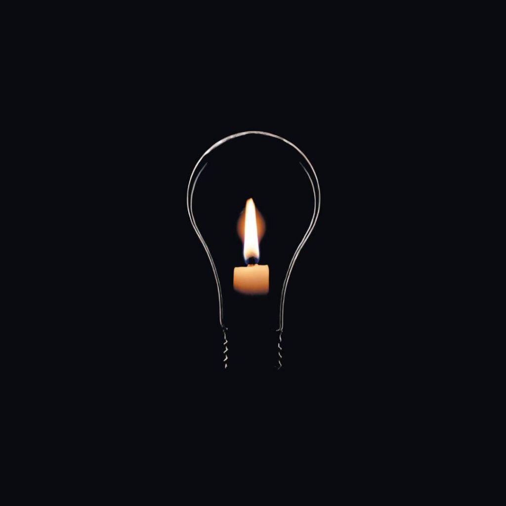Castiçal com vela acesa no formato de uma lâmpada, simbolizando o apagão elétrico.