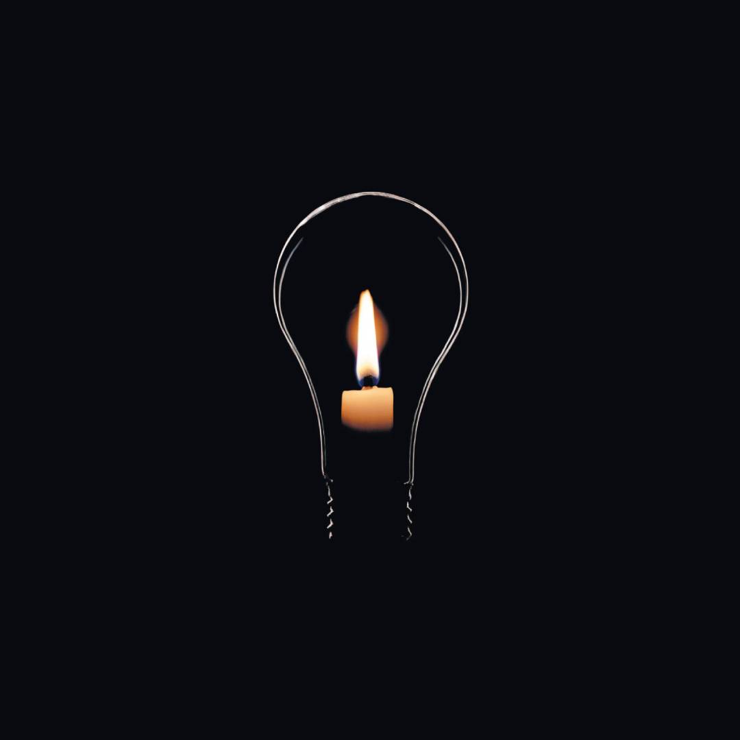 Castiçal com vela acesa no formato de uma lâmpada, simbolizando o apagão elétrico.
